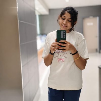 Digital Marketing Professional smiling while taking a mirror selfie in a modern indoor space.